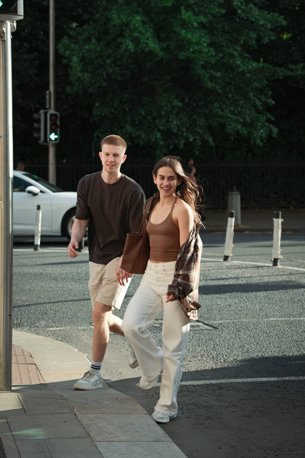 Couple laughing as they cross a city street together