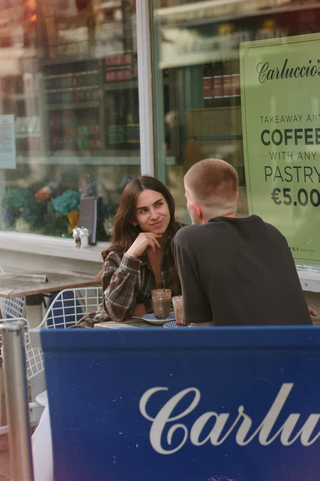 Couple chatting over coffee at a pavement café table