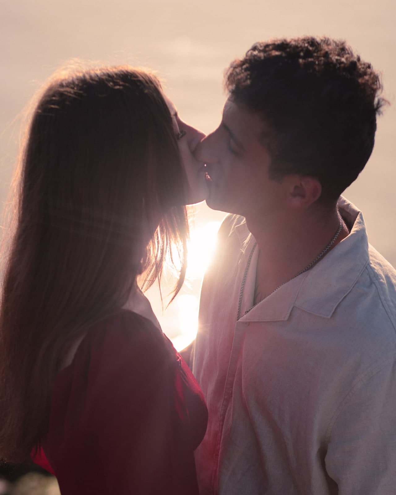 A kiss against the low sun, faces in silhouette