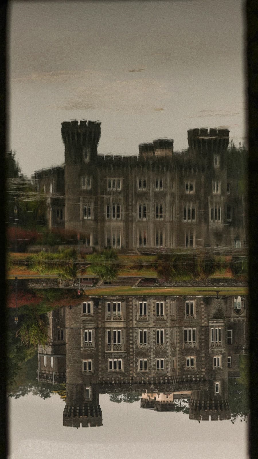 A castle with square towers mirrored in still water
