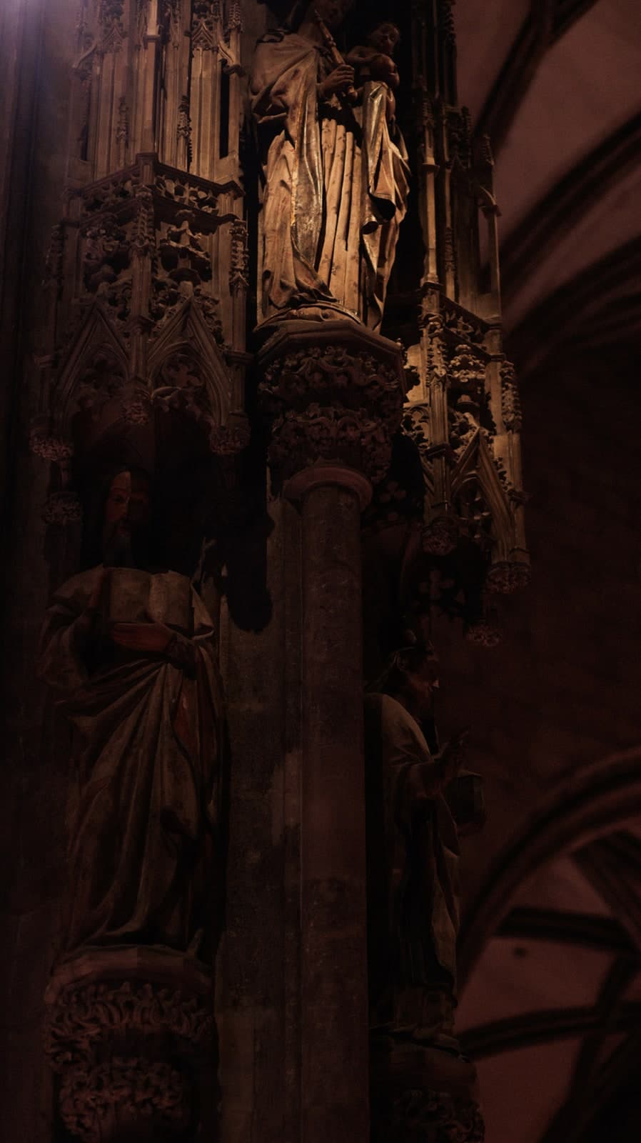 Carved stone saints in the dim interior of a Gothic cathedral